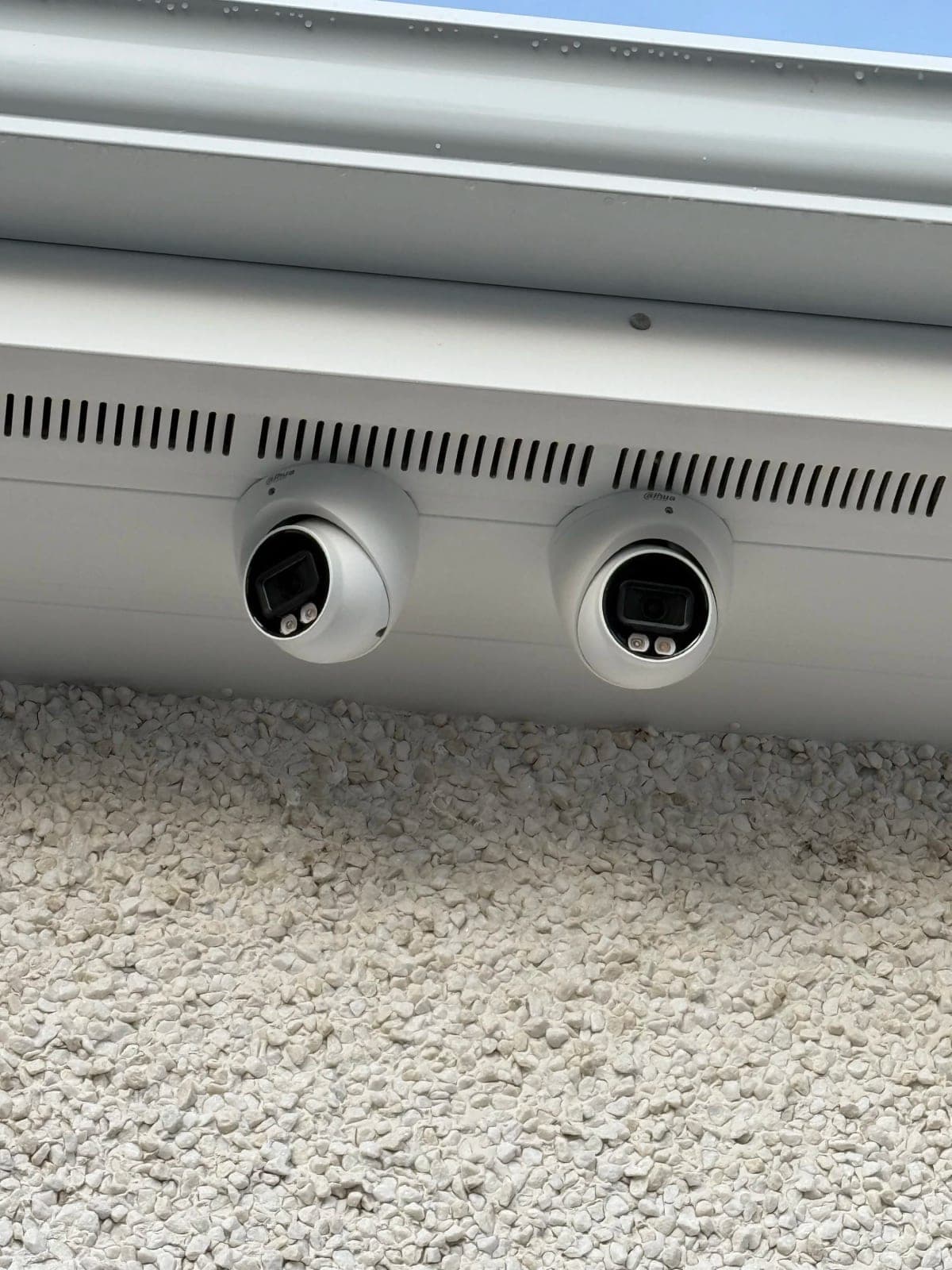 Two external CCTV cameras installed under the soffit of a building