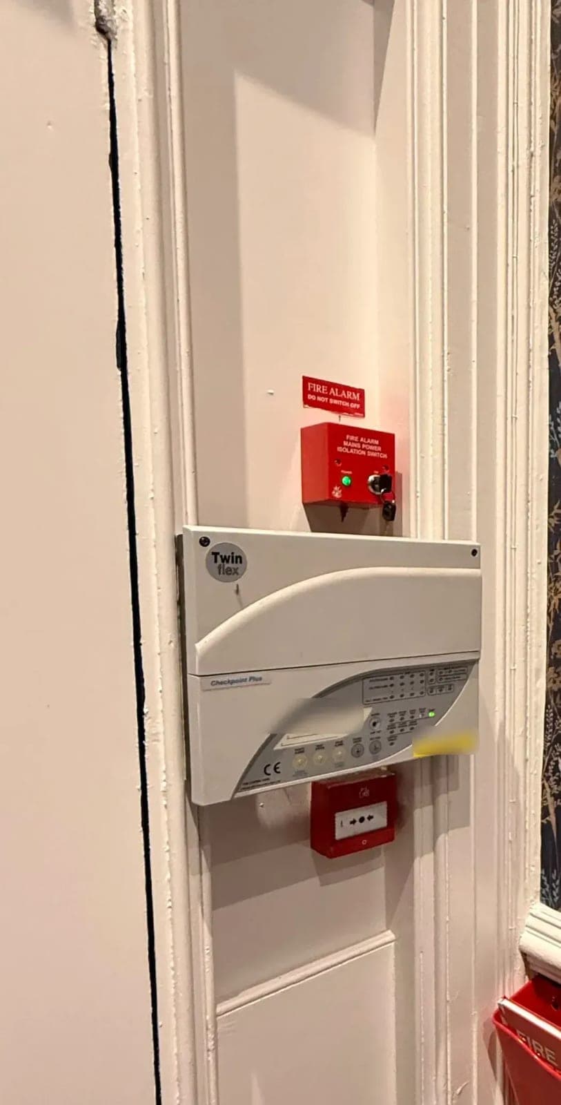 Fire alarm control panel, mains isolation switch and manual call point installed in a communal entrance