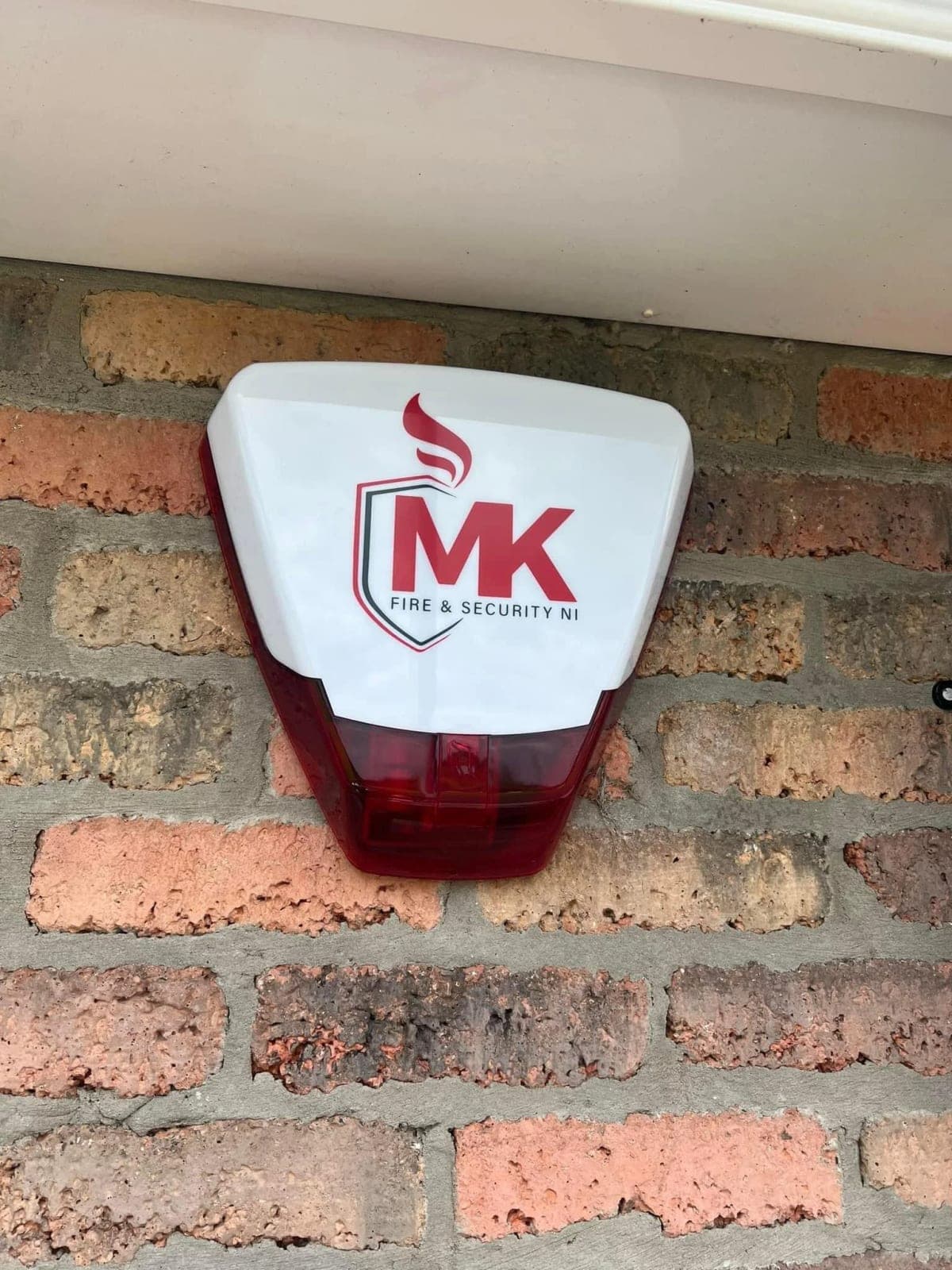 External intruder alarm sounder fitted below the eaves of a brick house
